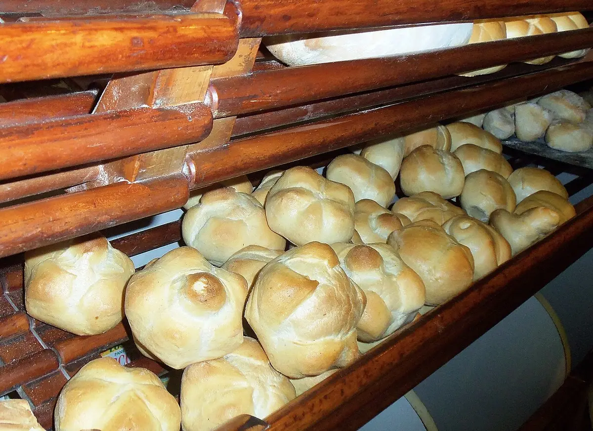Racks of puffed, star-topped michetta rolls in a bakery
