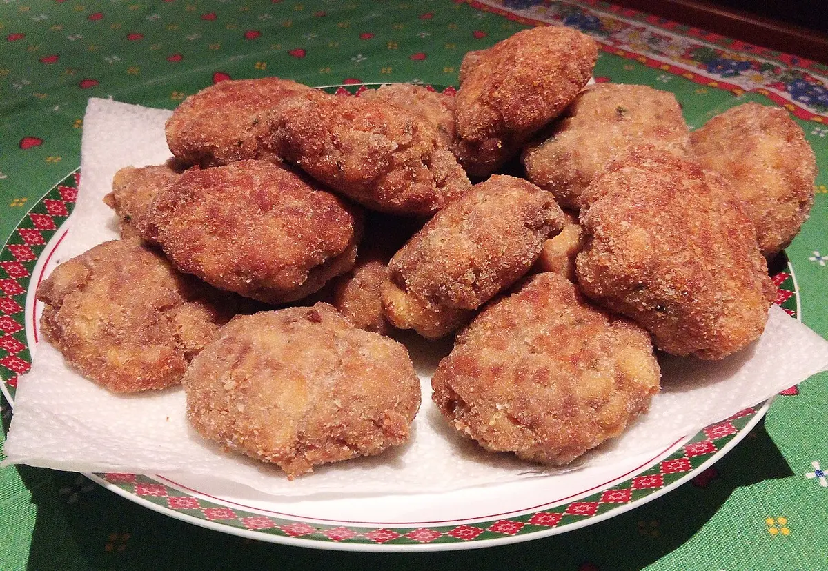 A plate of mondeghili, flattened fried meatballs