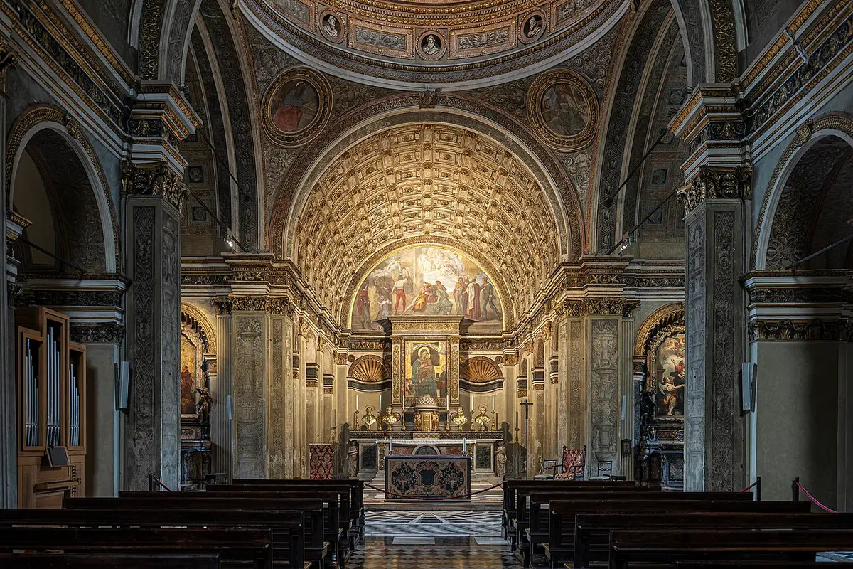 The nave of Santa Maria presso San Satiro ending in what looks like a deep coffered choir behind the altar