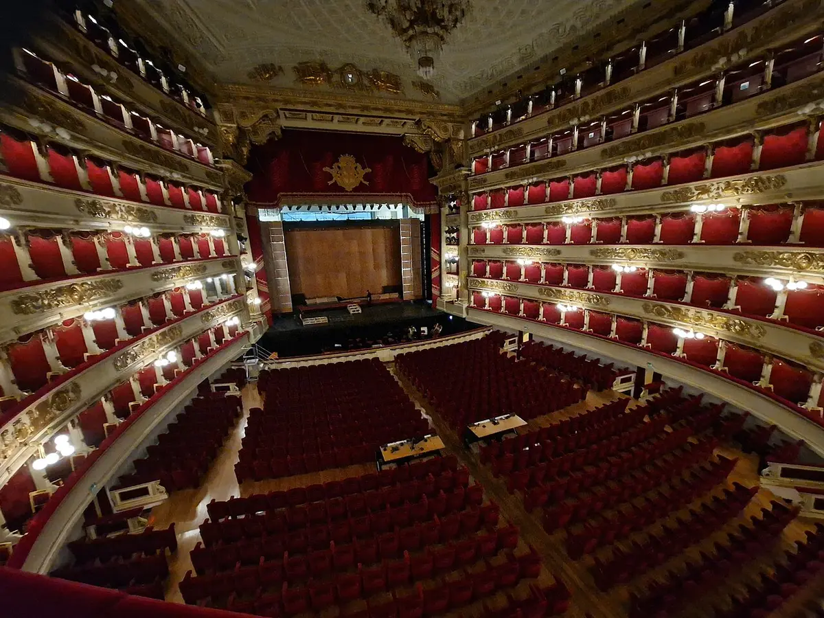 The auditorium of La Scala seen from a box, tiers of red boxes curving around the stalls and the stage