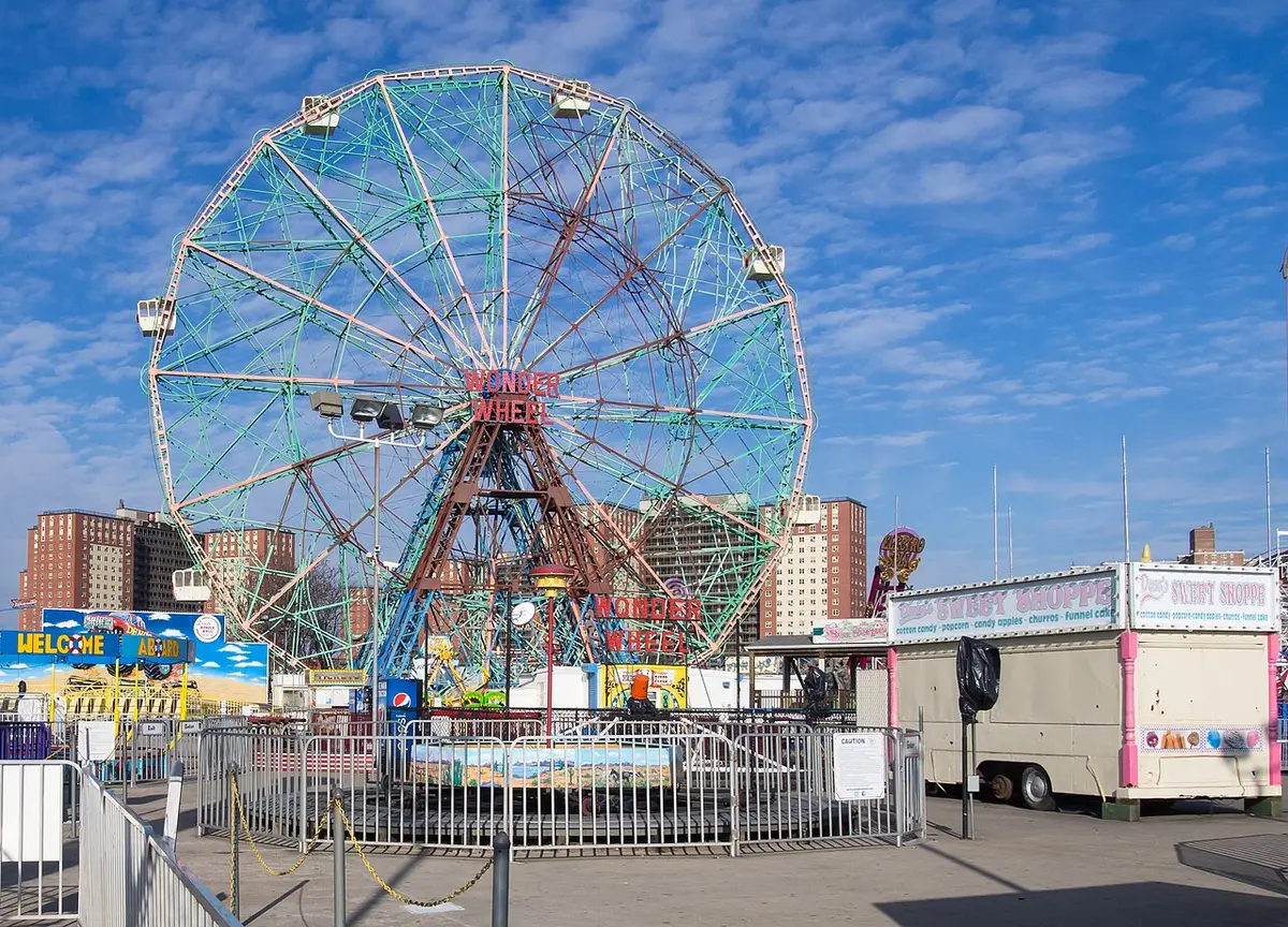 The Wonder Wheel, a tall green and red Ferris wheel, against a blue sky at Coney Island