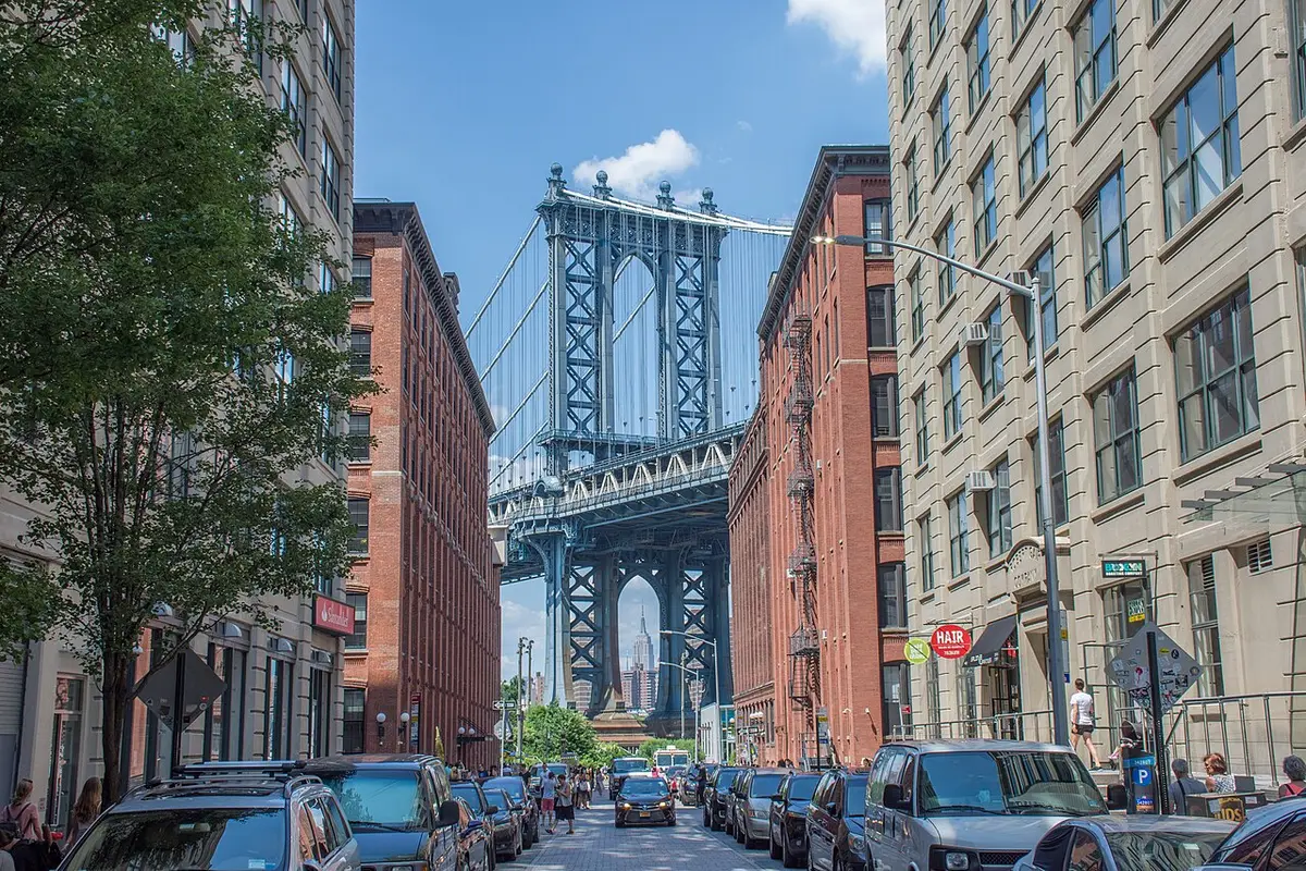 The Manhattan Bridge at the end of a DUMBO street, the Empire State Building framed in its arch
