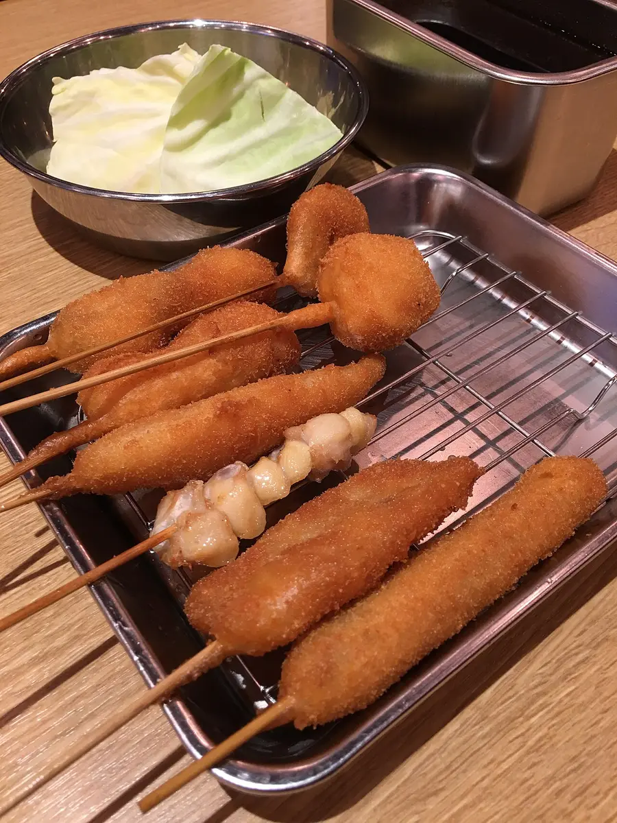 Breaded and fried kushikatsu skewers on a wire rack