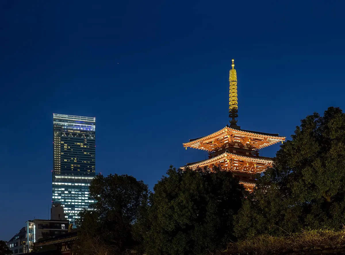 Shitennō-ji’s five-story pagoda lit at dusk, with the Abeno Harukas tower behind
