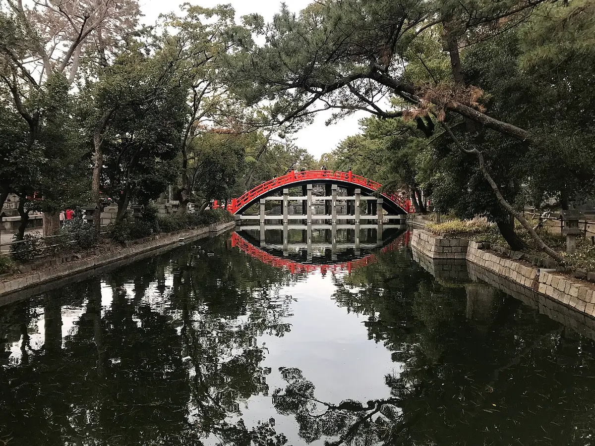 The steep red Sorihashi bridge at Sumiyoshi Taisha reflected in its pond