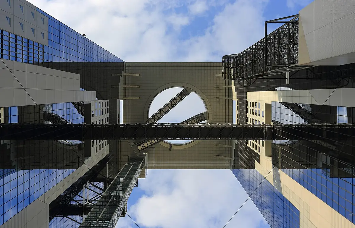 Looking up at the Umeda Sky Building, its two towers joined at the top by bridges and a ring-shaped rooftop