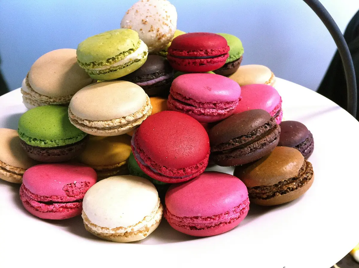 A pile of macarons in pink, green, brown, cream and red