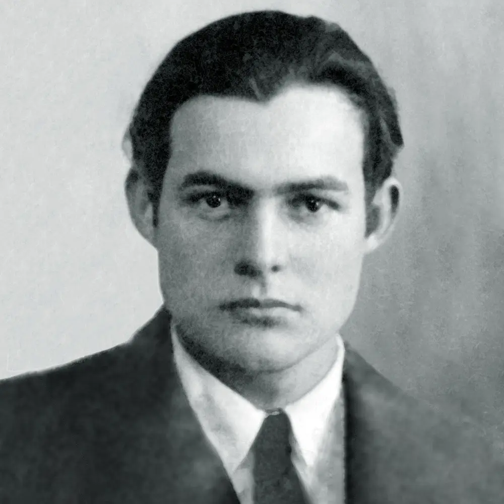 Black and white passport photograph of a young Ernest Hemingway in a jacket and tie
