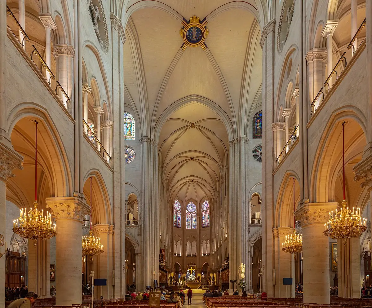 The nave of Notre-Dame after its restoration, pale stone vaults above rows of chandeliers