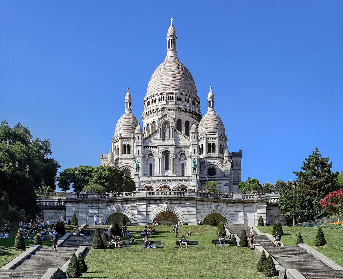 The white domes of Sacré-Cœur on top of Montmartre, above lawns and stairways