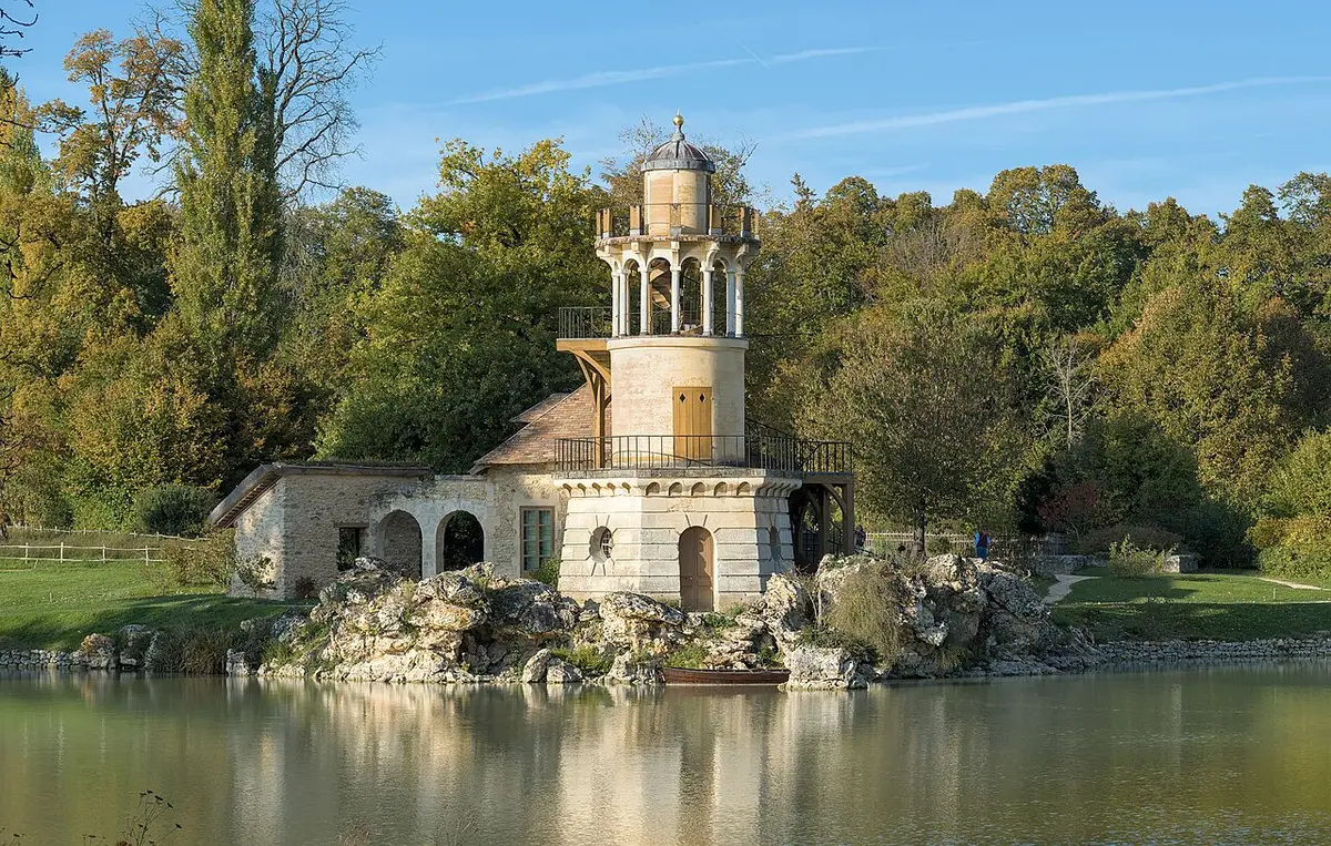 The Marlborough Tower and a cottage on a rocky bank beside the lake of the Queen’s Hamlet