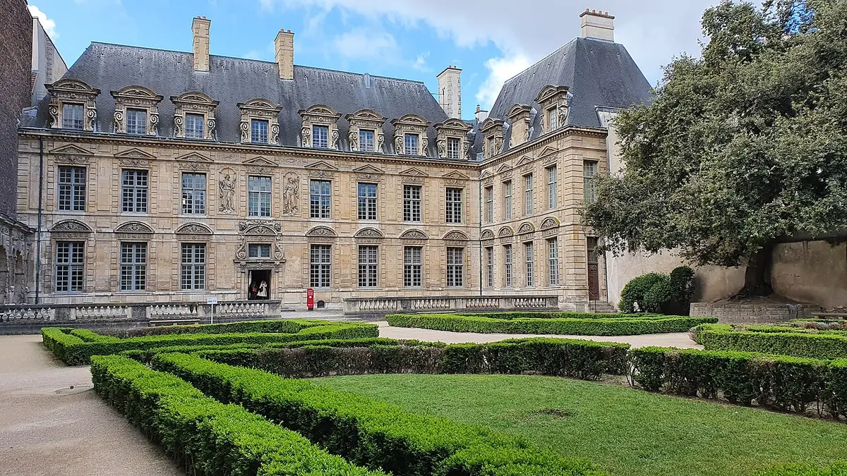 The garden front of the Hôtel de Sully above box hedges and a lawn