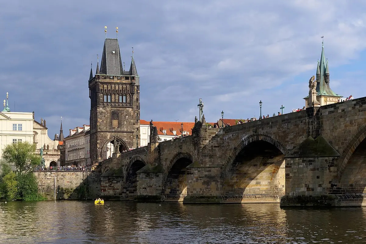 Charles Bridge seen from the river, its stone arches running to the Gothic Old Town Bridge Tower