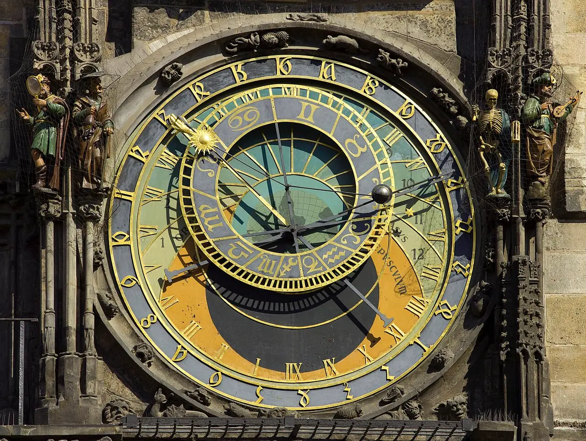 The astronomical dial of the Old Town Hall clock, with carved figures on either side