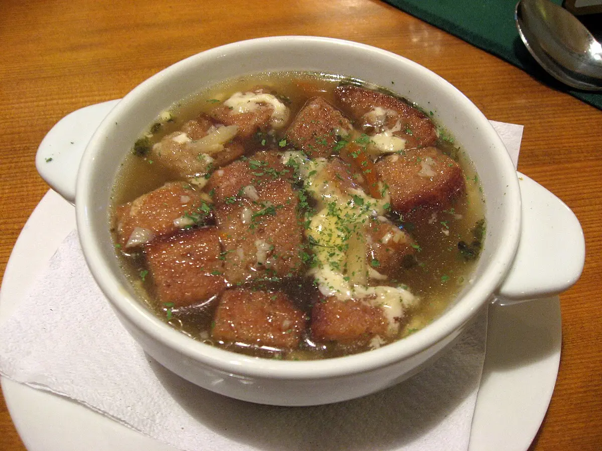 A bowl of garlic soup with fried bread croutons