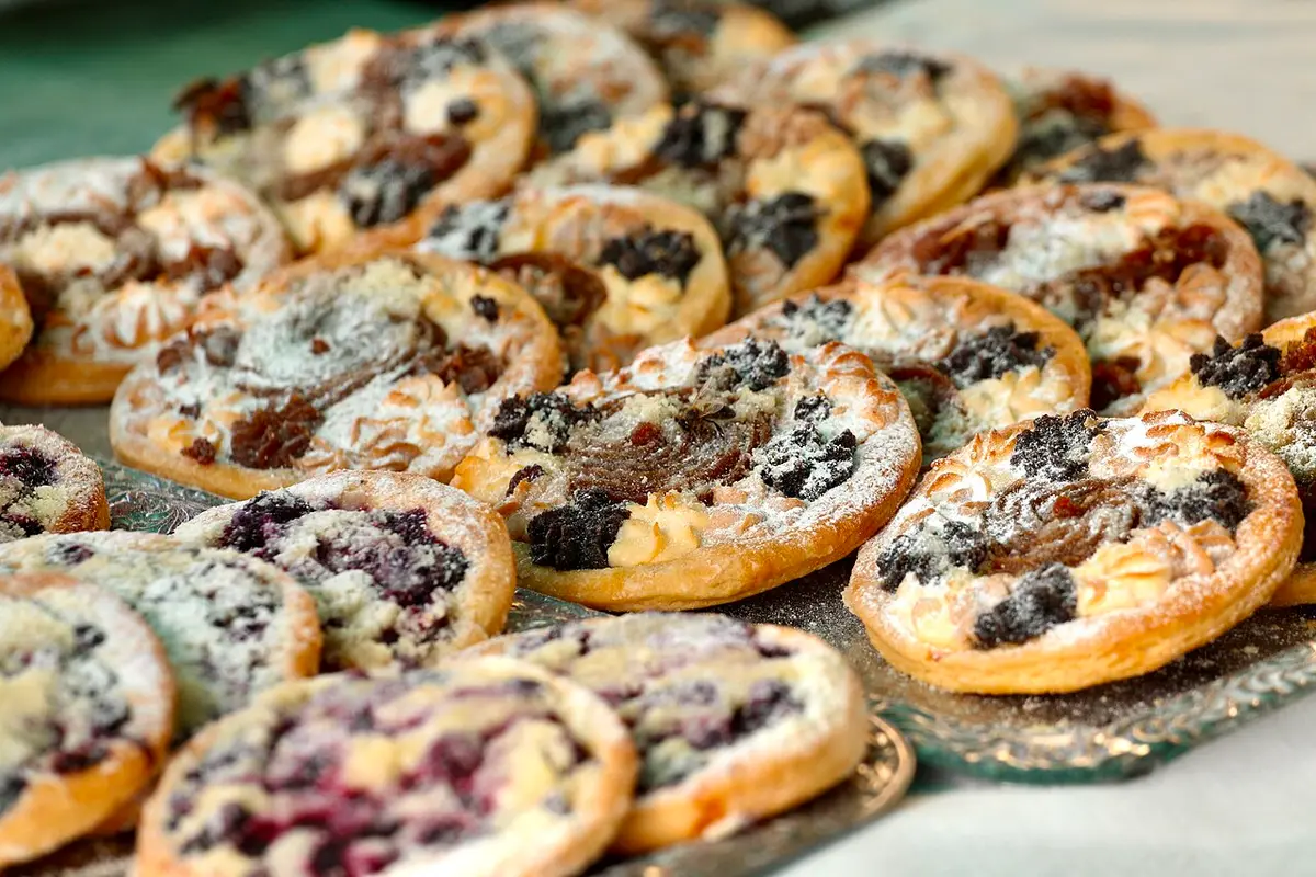 Round koláče pastries with fruit and poppy seed fillings, dusted with sugar