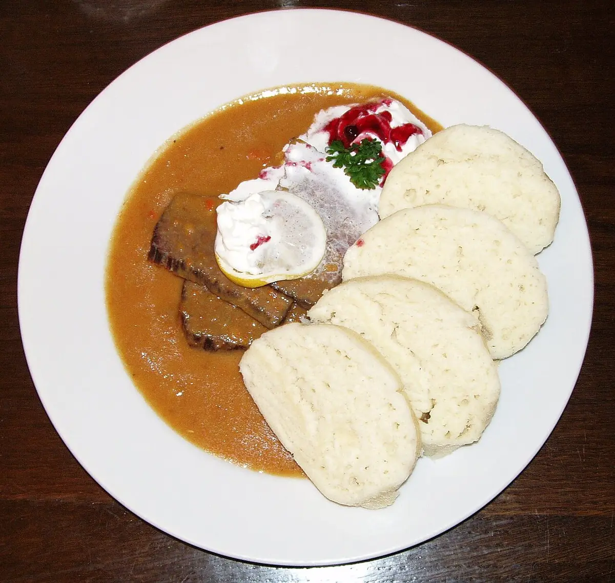 Svíčková: sliced beef in a cream sauce with bread dumplings, cranberries and whipped cream