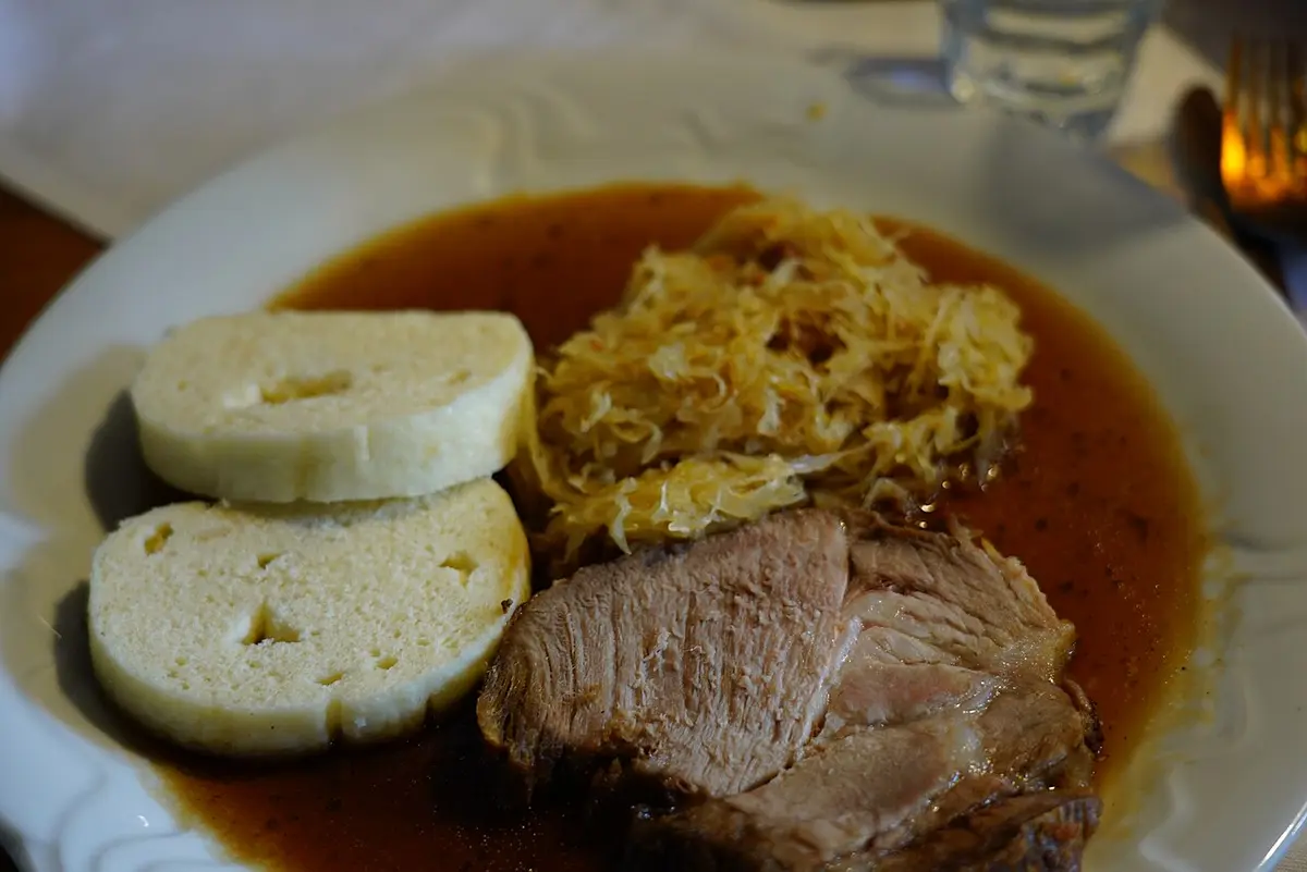 Roast pork with bread dumplings and sauerkraut in gravy
