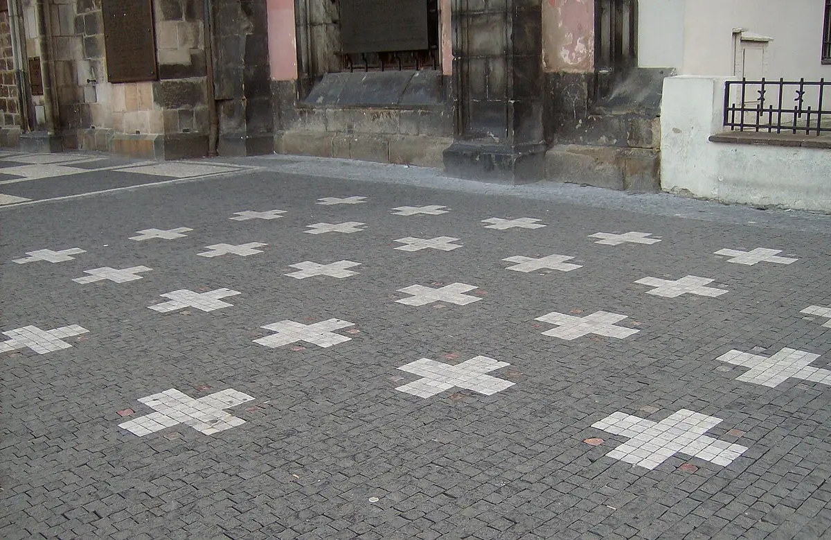 White crosses set into the dark cobbles of Old Town Square
