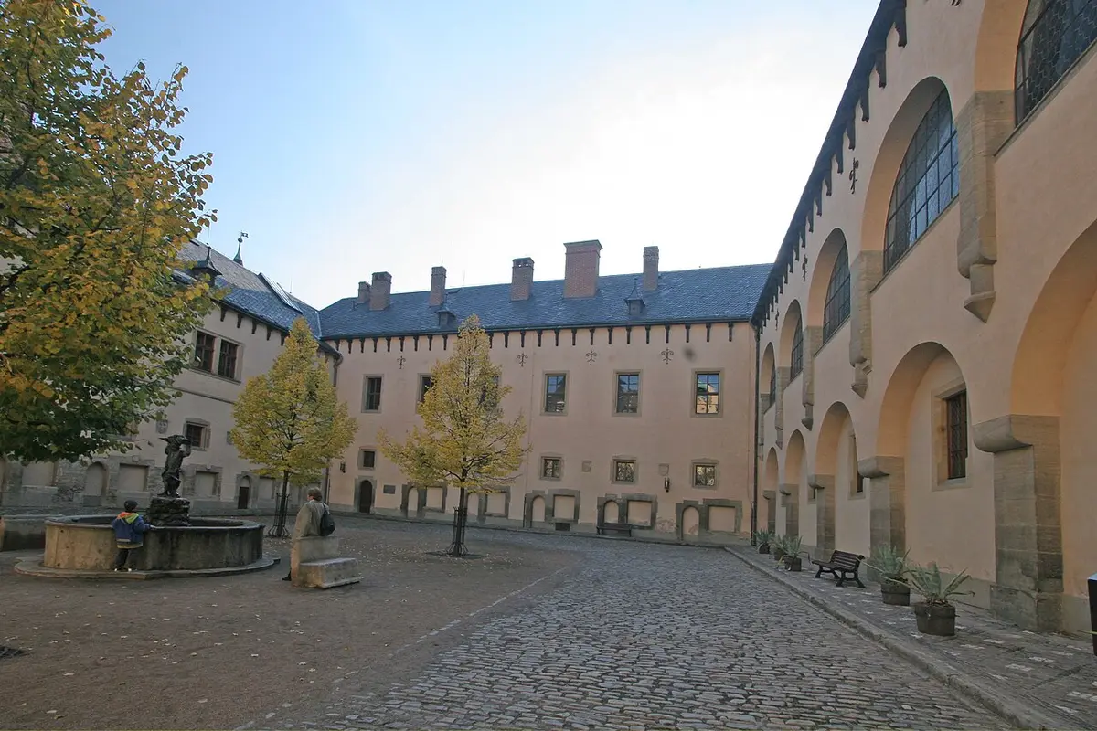 The arcaded courtyard of the Italian Court in Kutná Hora, with autumn trees