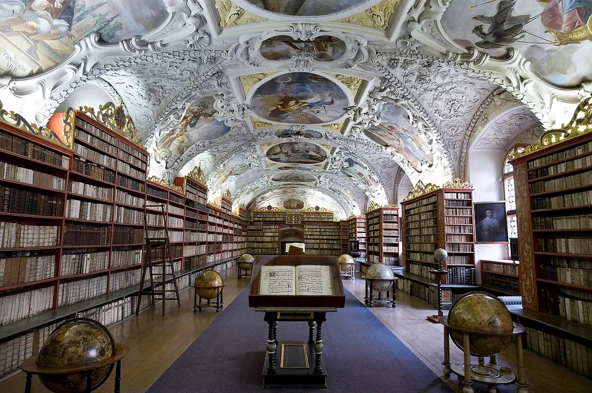 The Theological Hall of the Strahov Library: a painted stucco vault, baroque bookcases, globes and a reading desk
