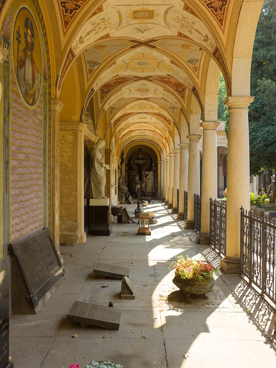 The painted arcade of Vyšehrad Cemetery, lined with tombs and sculpture