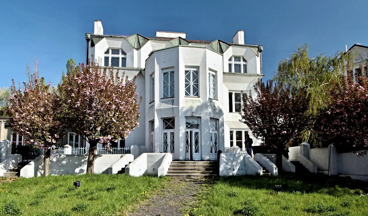 The white Cubist Kovařovic villa with angular bay windows, blossoming trees in its garden