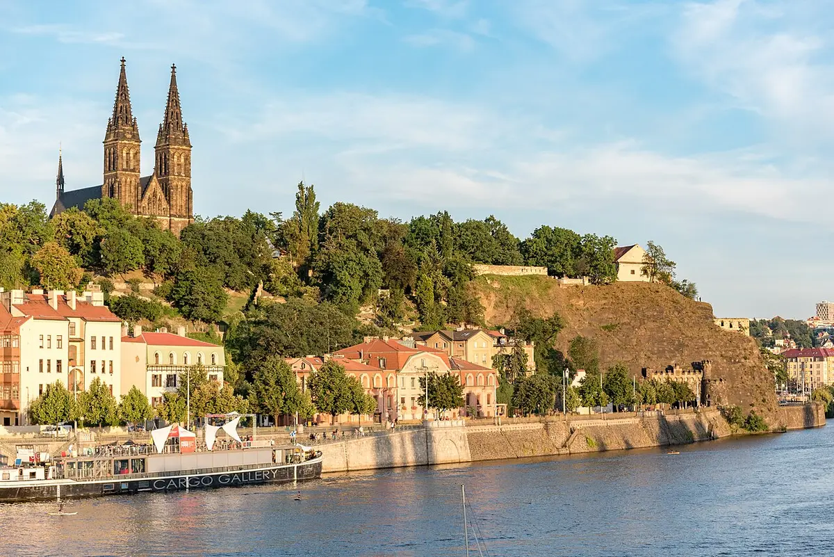 The Vyšehrad rock above the Vltava, the twin spires of the basilica on top and riverside houses below