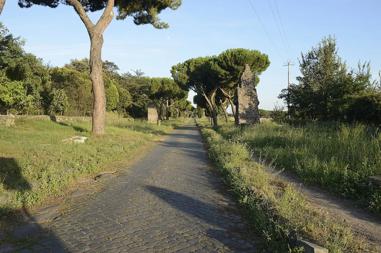 The ancient paving stones of the Appian Way between pines and cypresses