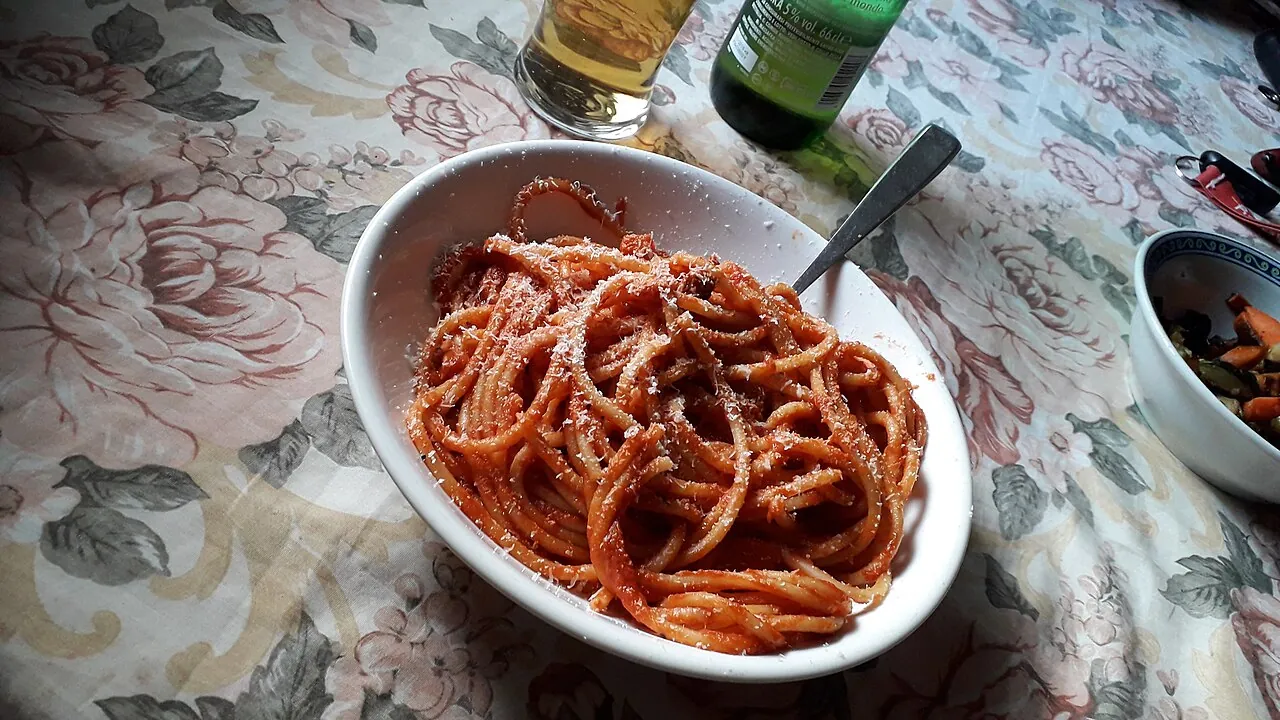 Bucatini all’amatriciana in a white bowl on a Roman kitchen table