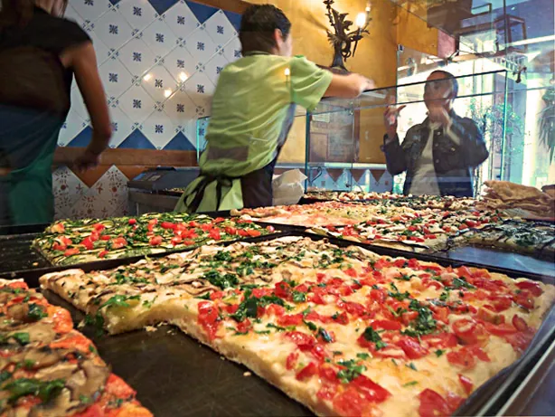Trays of pizza al taglio in a Roman shop