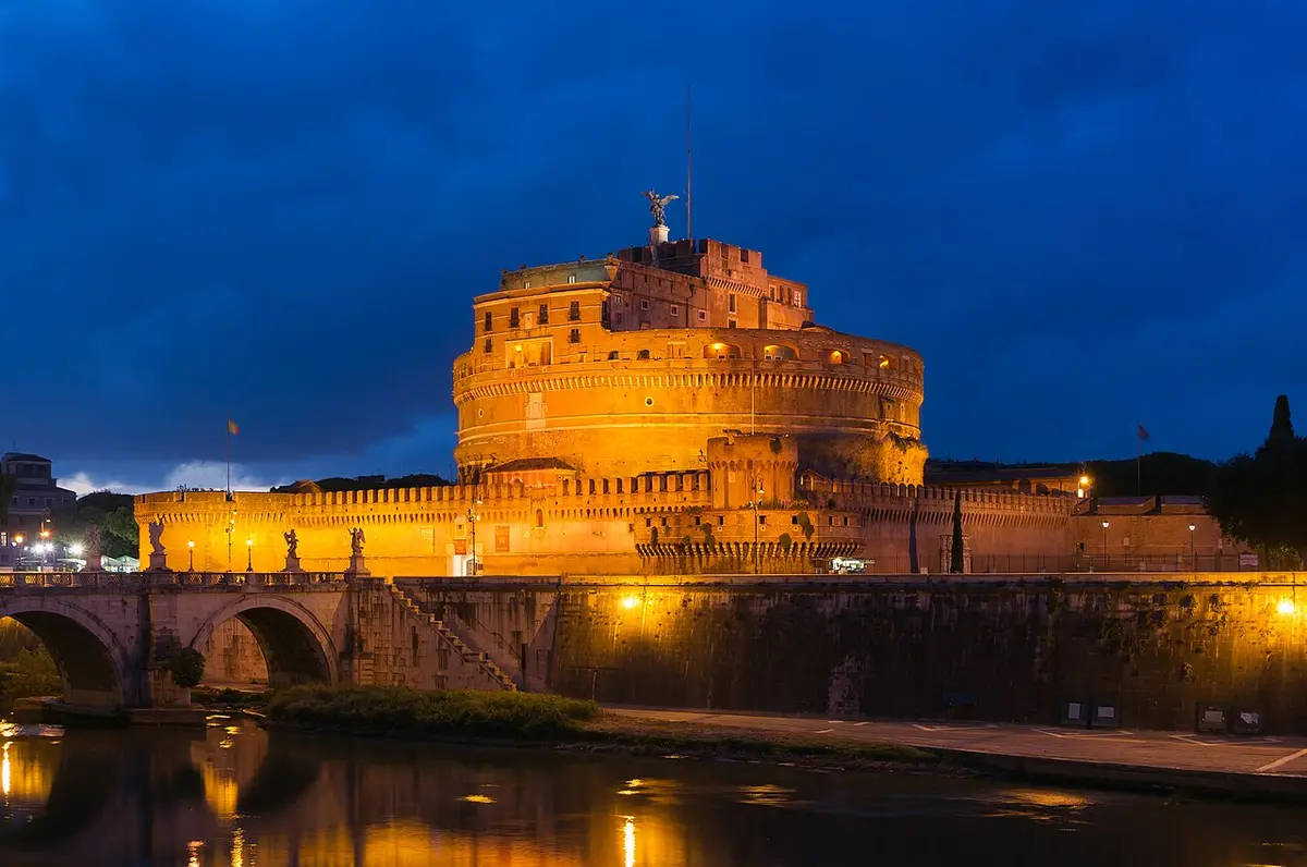 Castel Sant’Angelo lit up at dusk above the Tiber