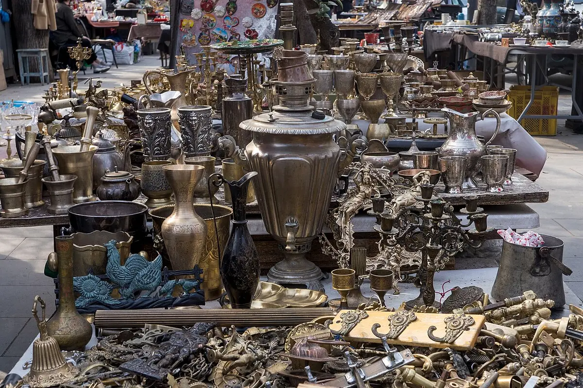 Brass samovars, jugs and candlesticks laid out for sale at the Dry Bridge market