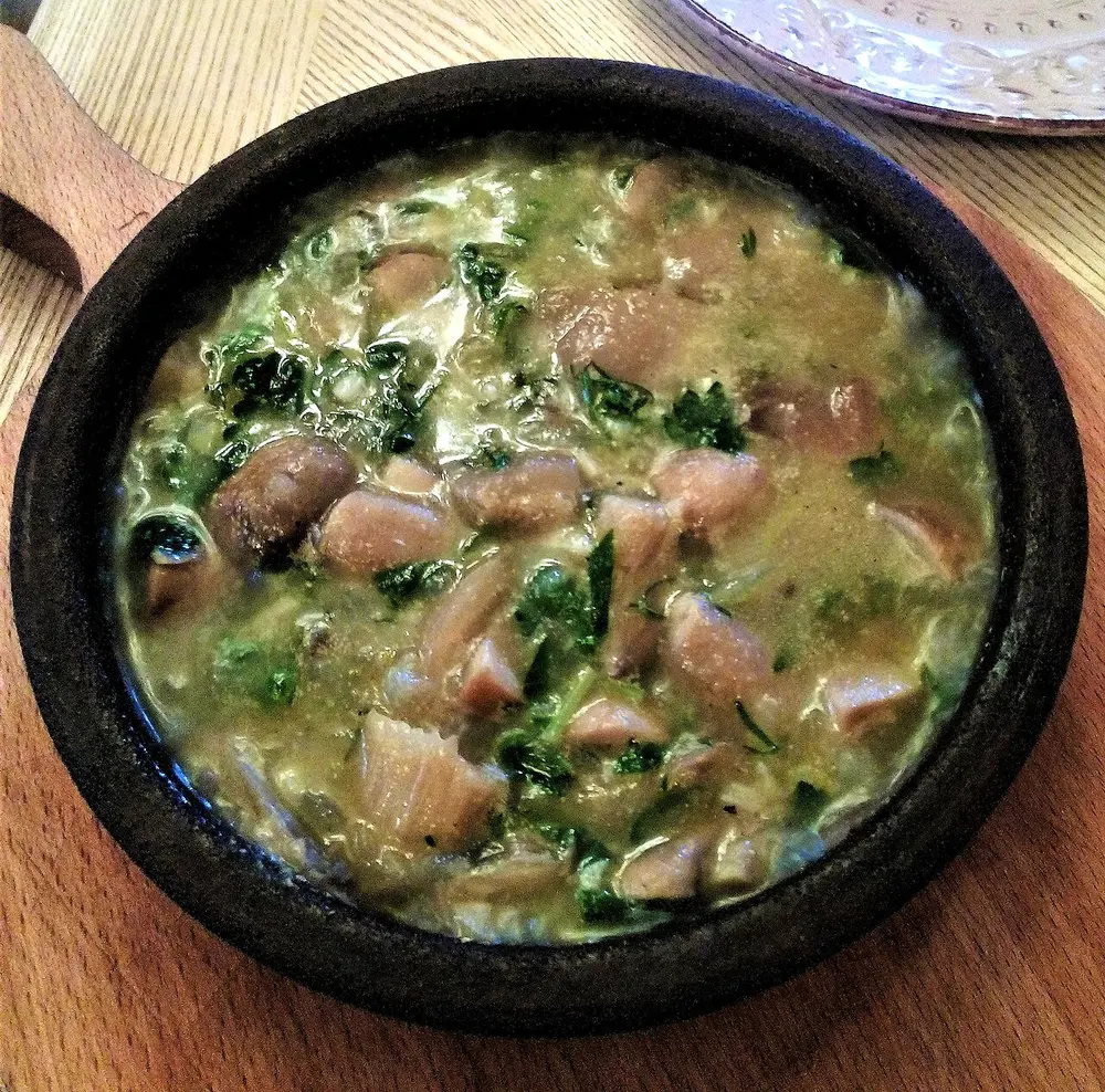 Chakapuli, a green stew of meat and tarragon, in a black clay pan