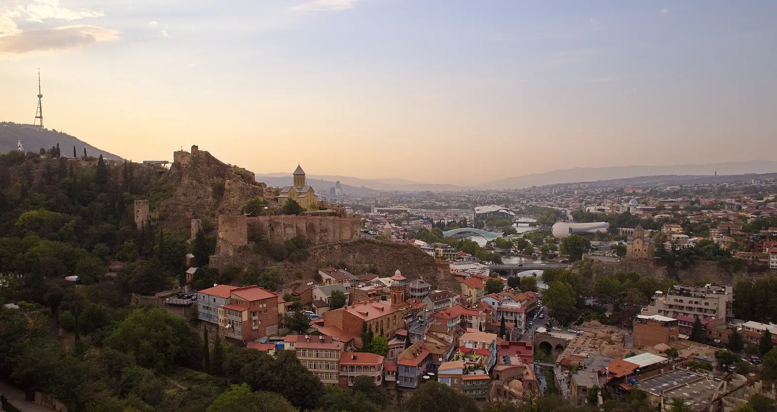 Old Tbilisi at dusk, the walls of Narikala above the river and the brick domes of the baths below