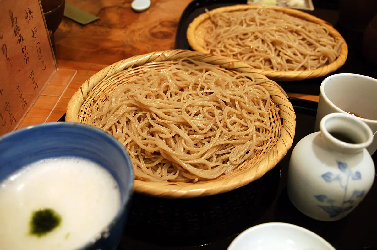 Cold soba noodles on round bamboo trays with a dipping sauce