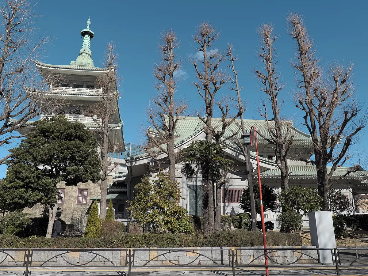 The Tokyo Memorial Hall and its tower among bare winter trees in Yokoamichō Park