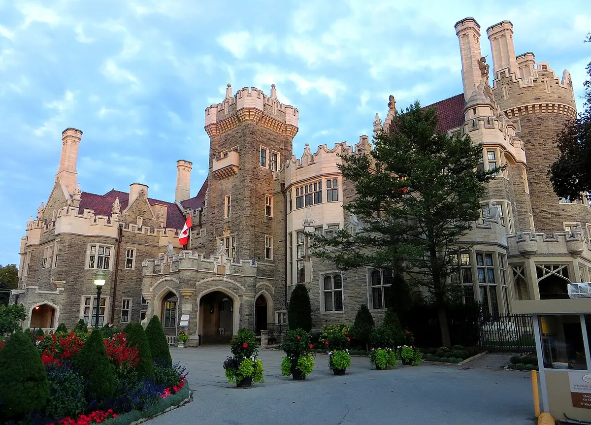 The towers and turrets of Casa Loma behind a garden of flower beds