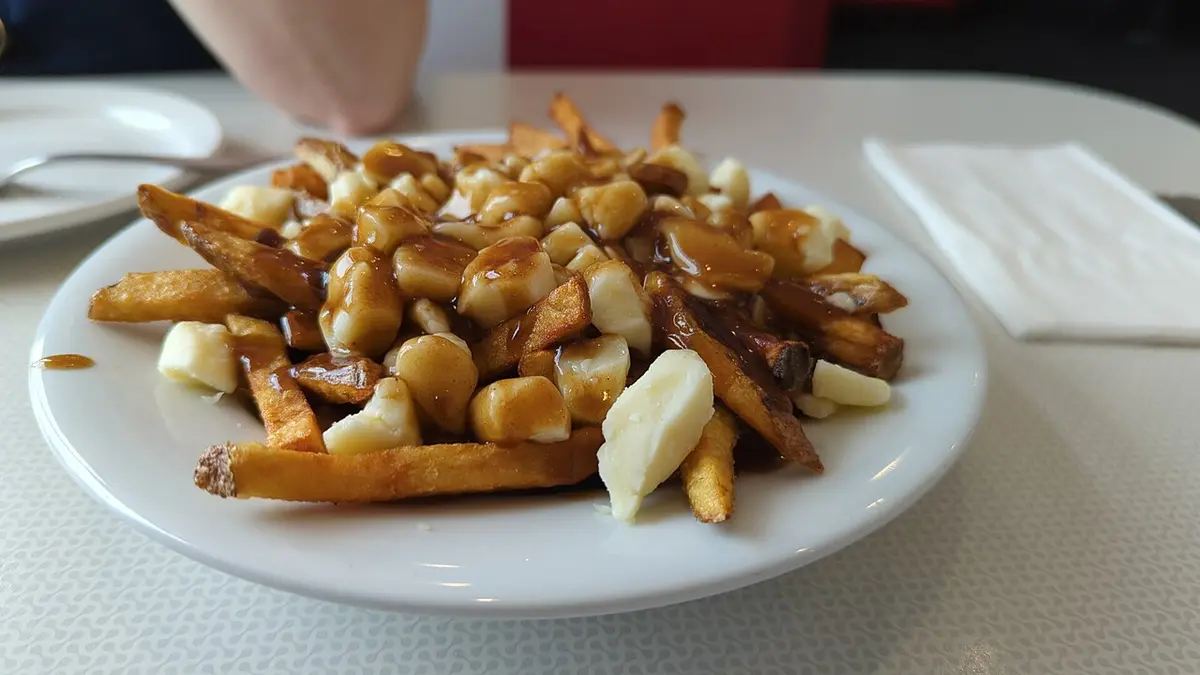 A plate of fries topped with cheese curds and gravy