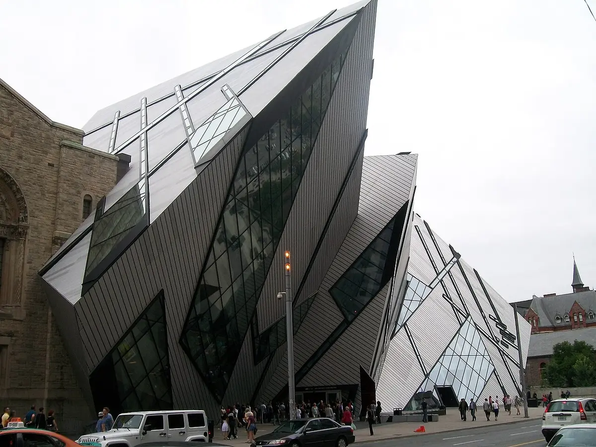 The angular glass and metal Crystal of the Royal Ontario Museum beside its older stone building on Bloor Street