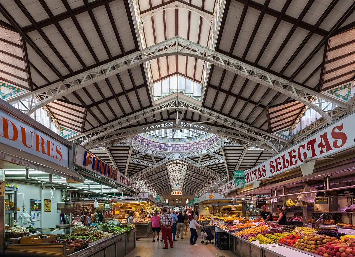 Stalls of fruit and vegetables under the iron and glass roof of Valencia’s Central Market